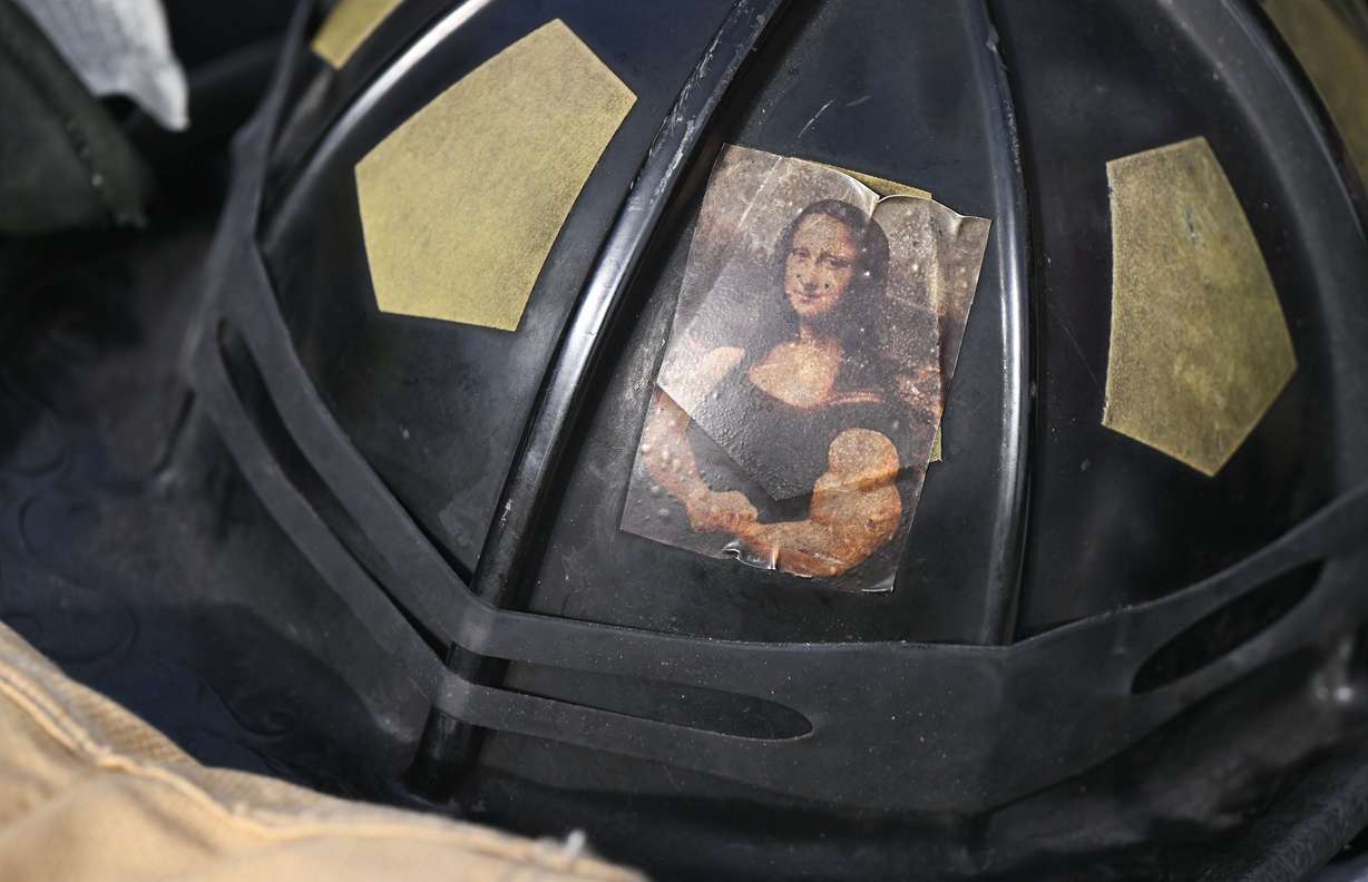 A muscular "Mona Lisa" sticker is displayed on a helmet, as firefighters compete for time in the SERVPRO FCL 2025 West Region Classic in the TFT Firefighter Challenge Championship Series, at the Utah State Fairpark in Salt Lake City on Friday.