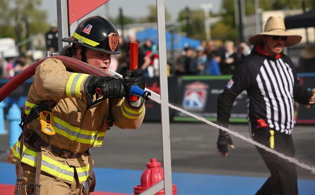 A firefighter shoots water at a target during a competition at the SERVPRO FCL 2025 West Region Classic in the TFT Firefighter Challenge Championship Series, at the Utah State Fairpark in Salt Lake City on Friday.