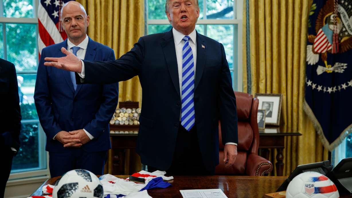 FILE - FIFA president Gianni Infantino, left, watches as President Donald Trump speaks to reporters during a meeting in the Oval Office of the White House, Aug. 28, 2018, in Washington.