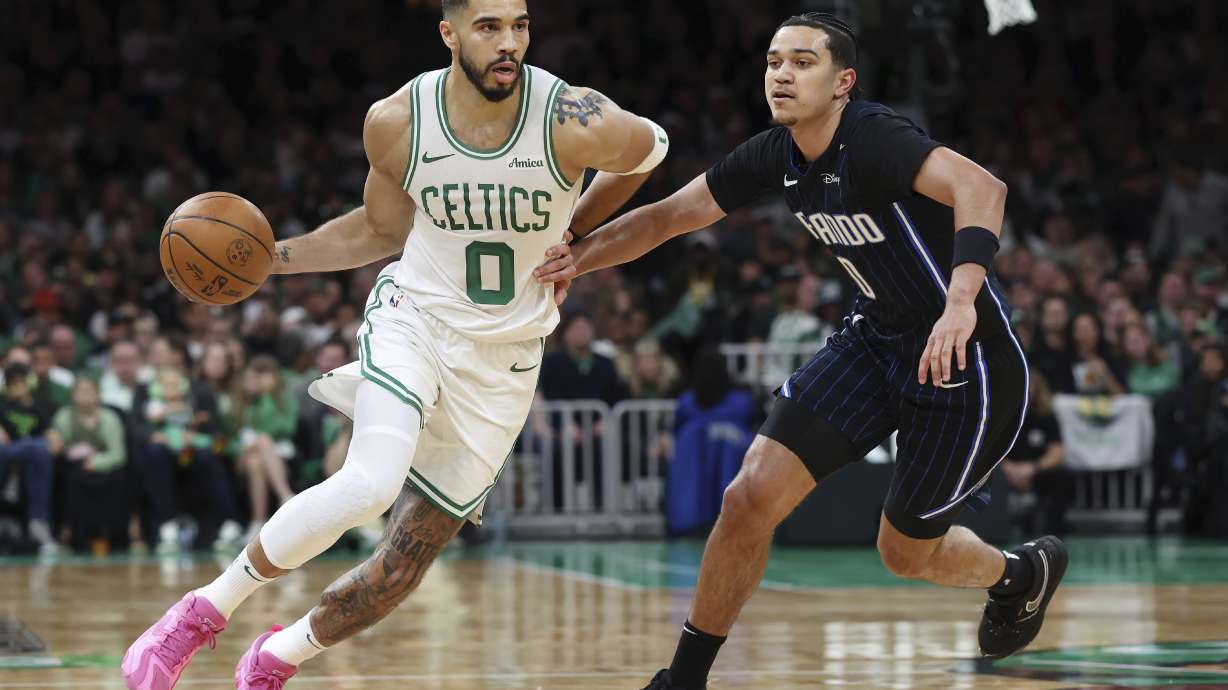 Boston Celtics' Jayson Tatum, left, drives past Orlando Magic's Anthony Black during the first half in game 1 of a first-round NBA playoff basketball series Sunday, April 20, 2025, in Boston.