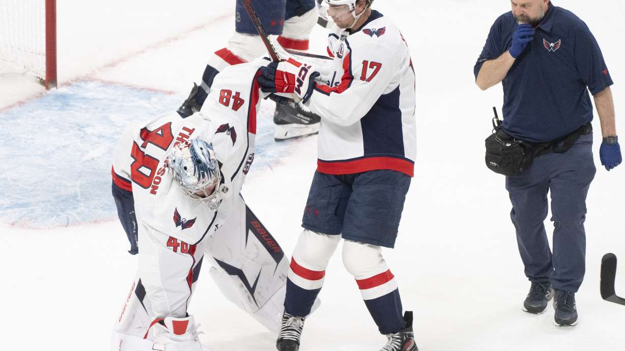 Washington Capitals goaltender Logan Thompson (48) stumbles as he is helped off the ice by teammate Dylan Strome during the third period of Game 3 of a first-round NHL hockey playoff series against the Montreal Canadiens in Montreal, Friday, April 25, 2025. (Christinne Muschi/The Canadian Press via AP