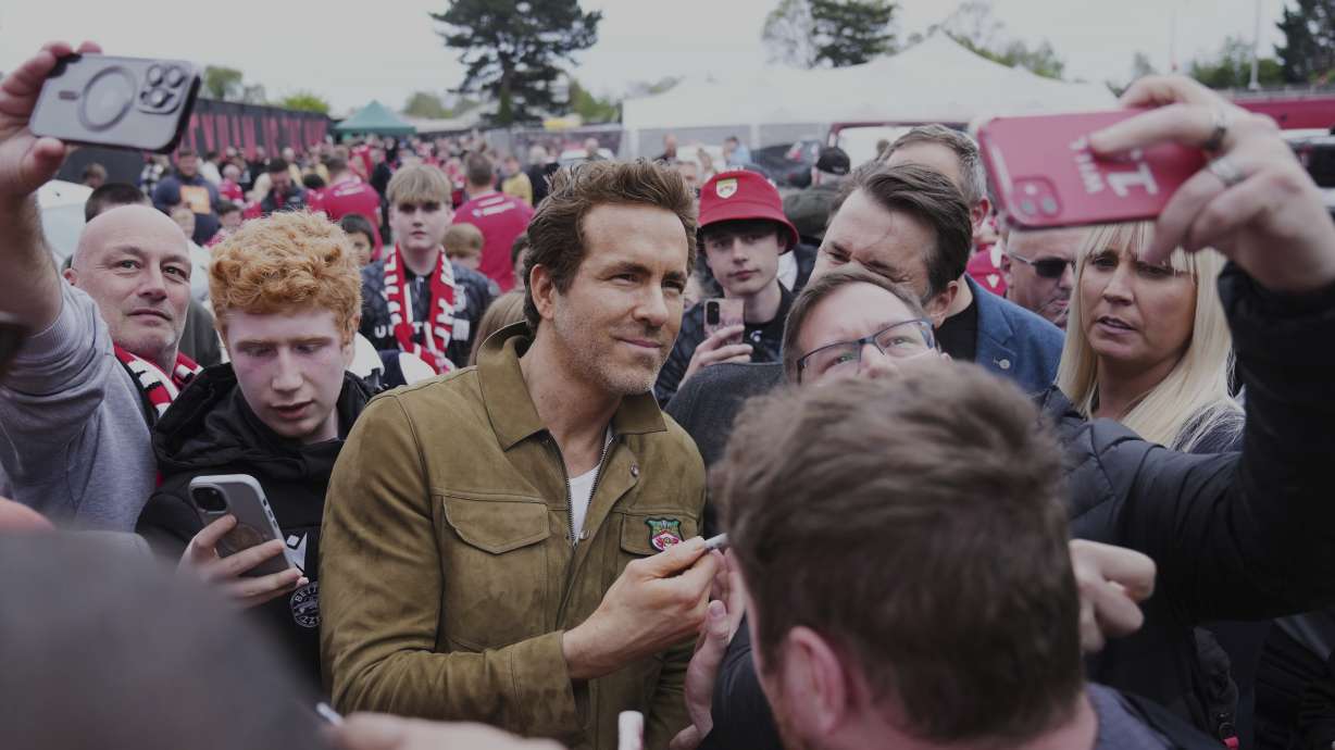 Wrexham co-owner Ryan Reynolds, center, arrives at the Racecourse ground stadium prior to the English League One soccer match between Wrexham and Charlton Athletic in Wrexham, Wales, Saturday, April 26, 2025.