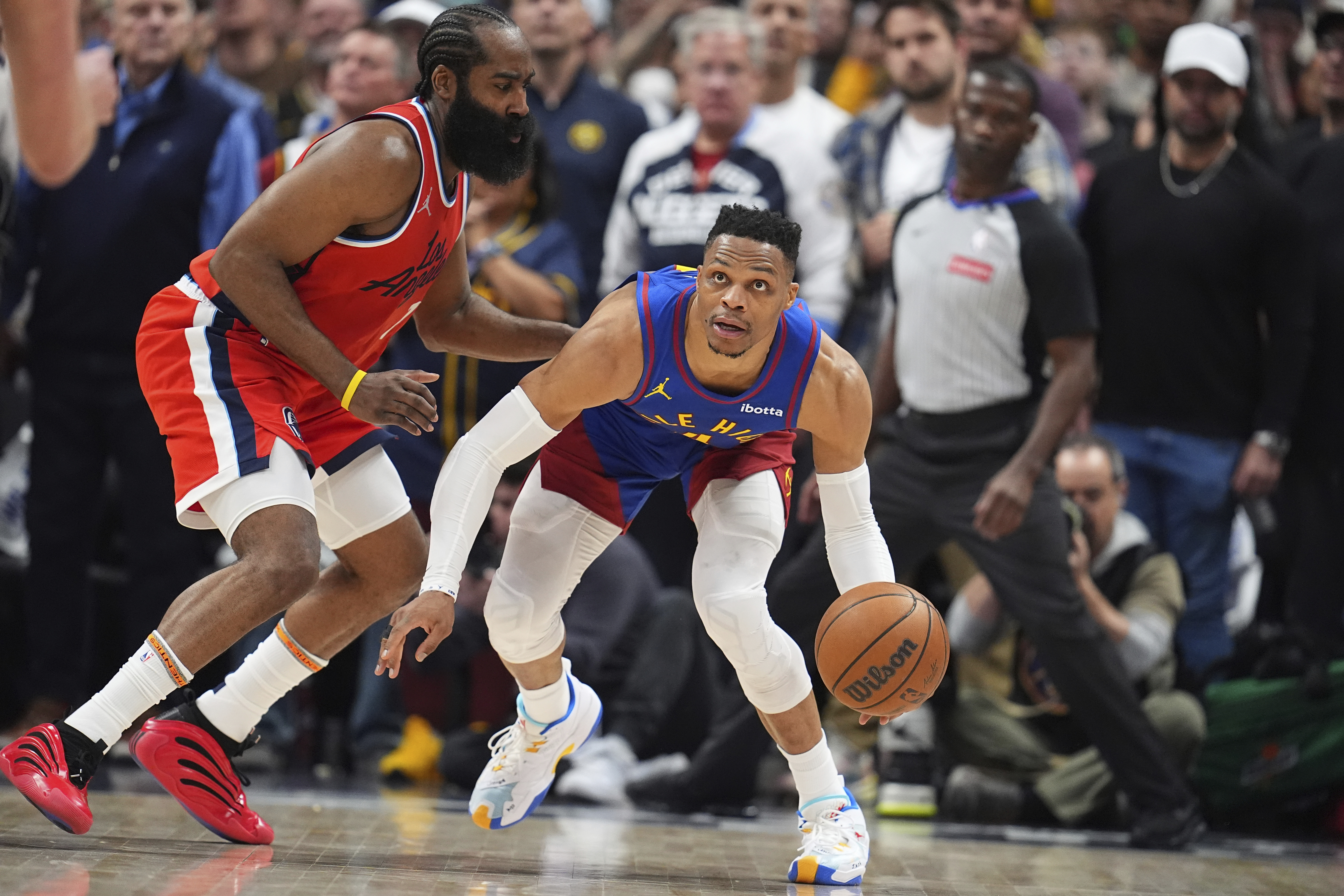 Denver Nuggets guard Russell Westbrook, right, looks to pass the ball as Los Angeles Clippers guard James Harden, left, defends in the second half of Game 1 of an NBA first-round playoff series Saturday, April 19, 2025, in Denver.