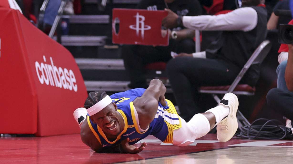 Golden State Warriors' Jimmy Butler III writhes in pain after injuring himself in 1st quarter against Houston Rockets in Game 2 of First Round of NBA Playoffs at Toyota Center in Houston, Texas on Wednesday, April 23, 2025.