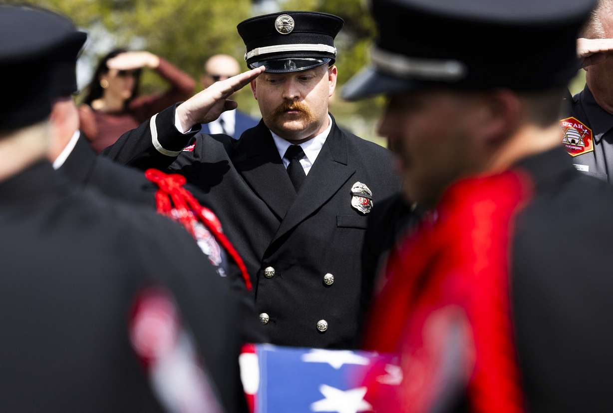South Jordan Fire Department paramedic John Weaver salutes and looks down as South Jordan firefighter Corban Summers’ casket is carried into Hunter High School for Summers’ funeral in West Valley City on Saturday.