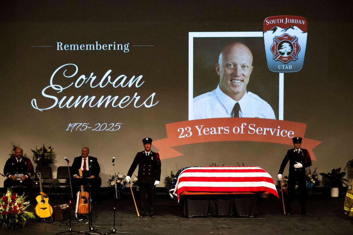 Firefighters stand guard over the casket during a funeral service for South Jordan firefighter Corban Summers at Hunter High School in West Valley City on Saturday.