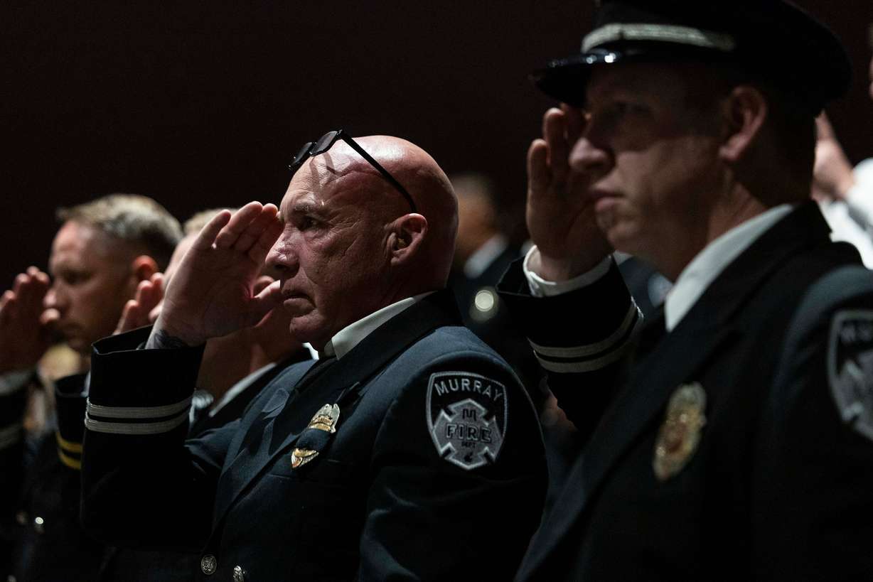 Murray firefighters salute during a funeral service for South Jordan firefighter Corban Summers at Hunter High School in West Valley City on Saturday.