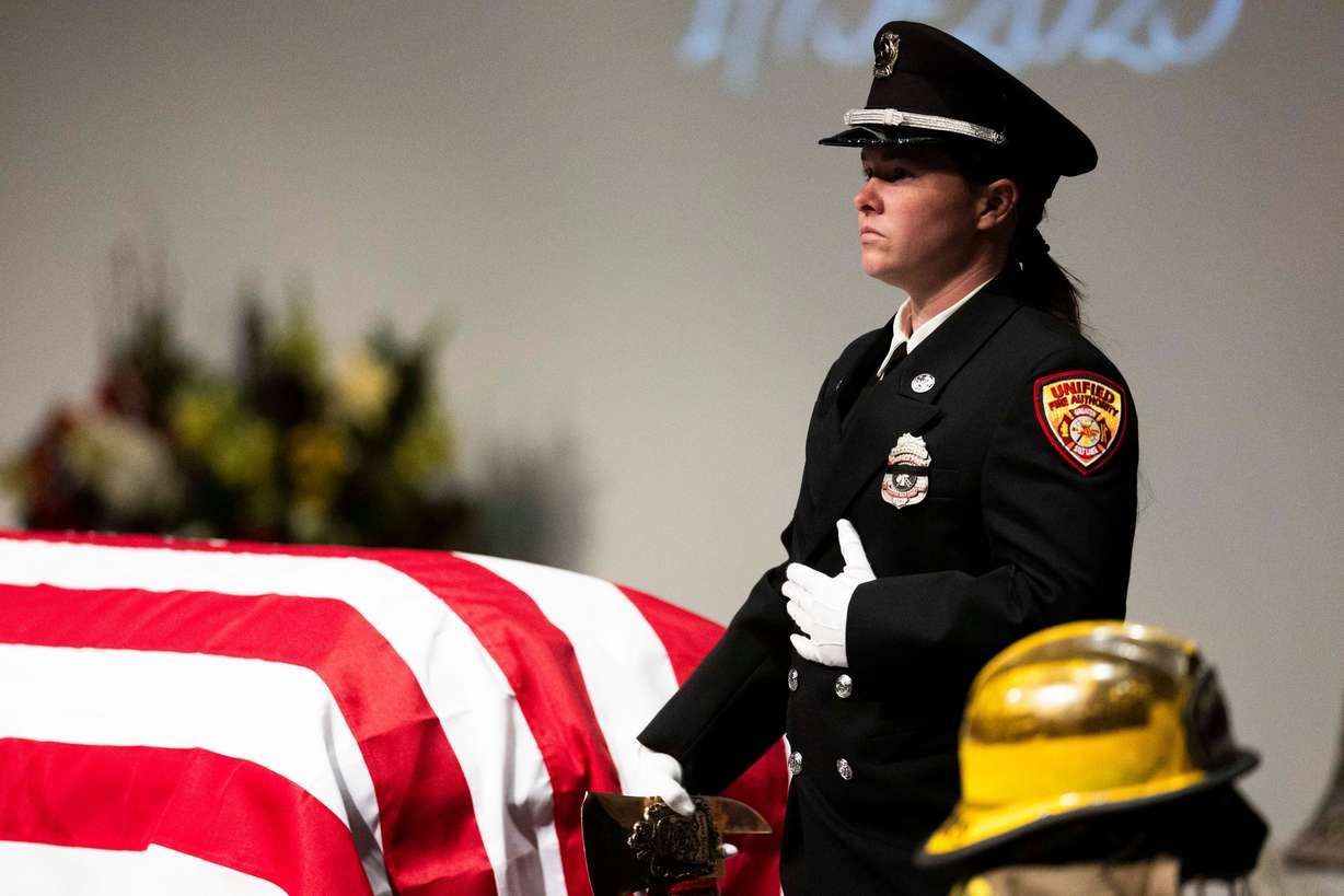 A firefighter stands guard over the casket during a funeral service for South Jordan firefighter Corban Summers at Hunter High School in West Valley City on Saturday.