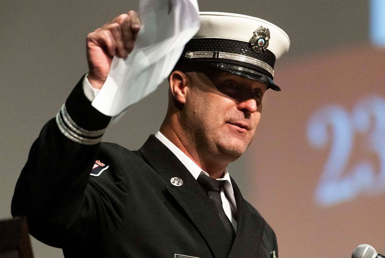 Las Vegas Fire Department Capt. Ben Penick holds up papers full of stories about South Jordan firefighter Corban Summers while Penick speaks during a funeral service for Corban Summers at Hunter High School in West Valley City on Saturday.