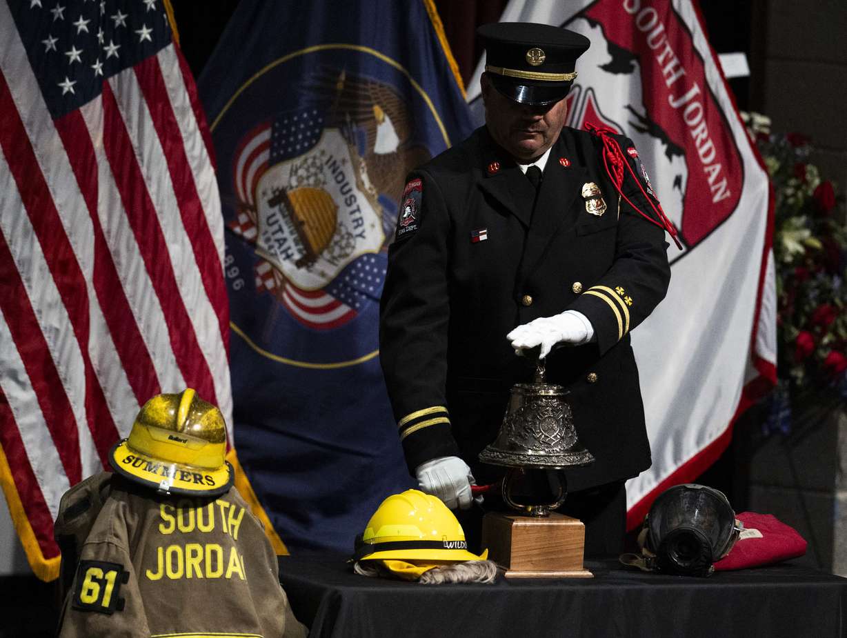 A firefighter rings a bell for the End of Watch ceremony during a funeral service for South Jordan firefighter Corban Summers at Hunter High School in West Valley City on Saturday.