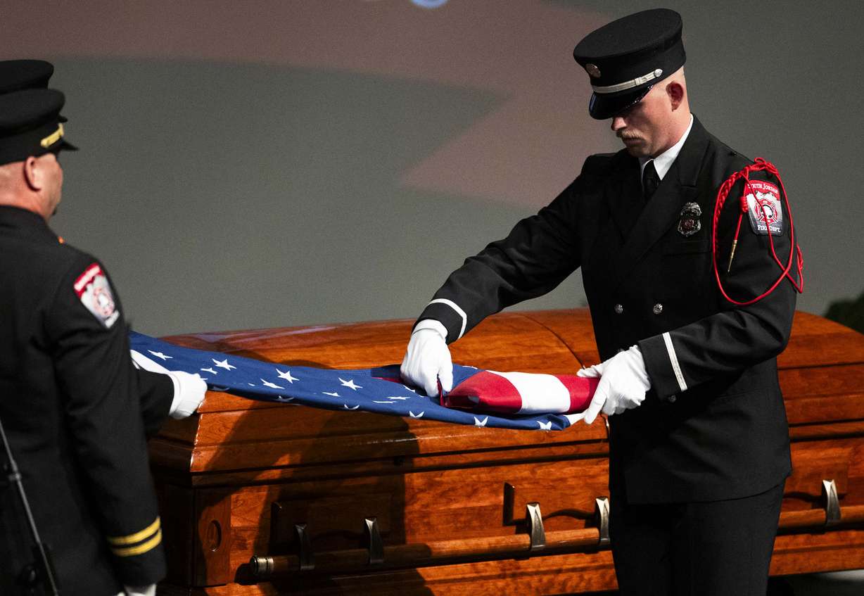 Firefighters fold the flag from the casket during a funeral service for South Jordan firefighter Corban Summers at Hunter High School in West Valley City on Saturday.
