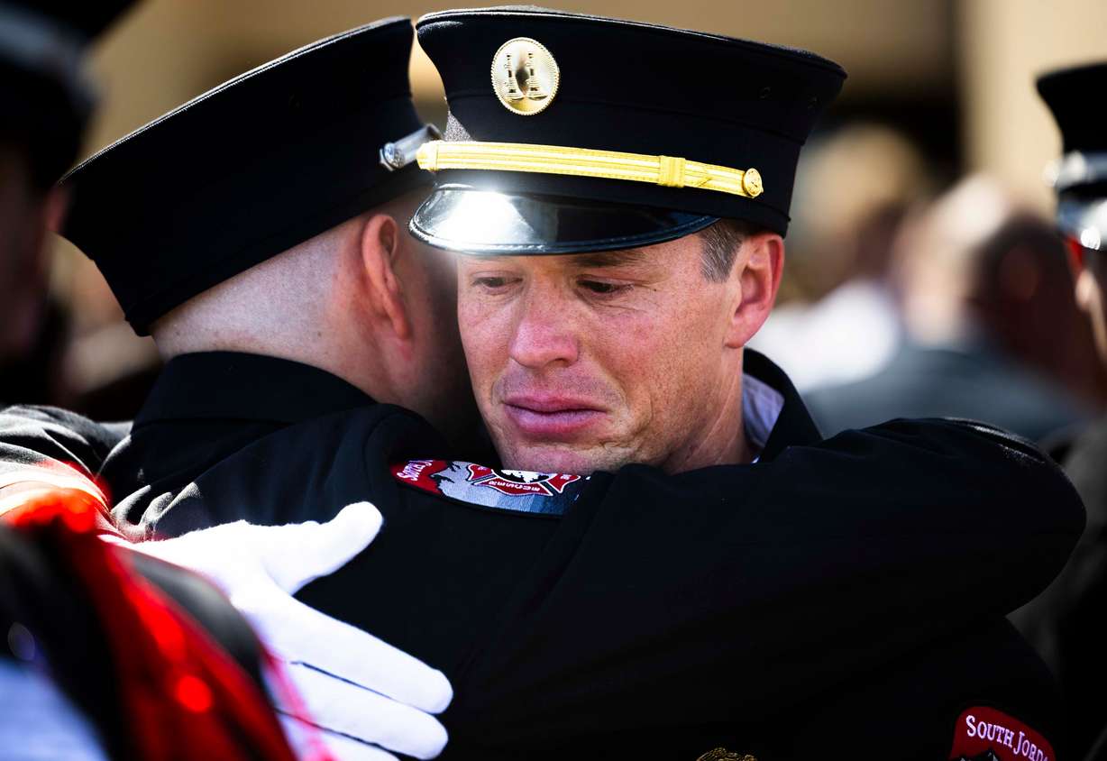 South Jordan firefighter Kendell Iverson hugs another South Jordan firefighter after a funeral service for South Jordan firefighter Corban Summers at Hunter High School in West Valley City on Saturday.