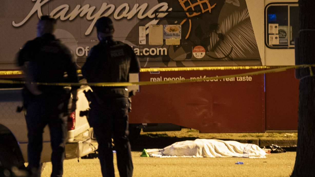 A victim covered with a cloth lies near a food truck after a car drove into a crowd at the Lapu Lapu Festival in Vancouver, British Columbia, Saturday.
