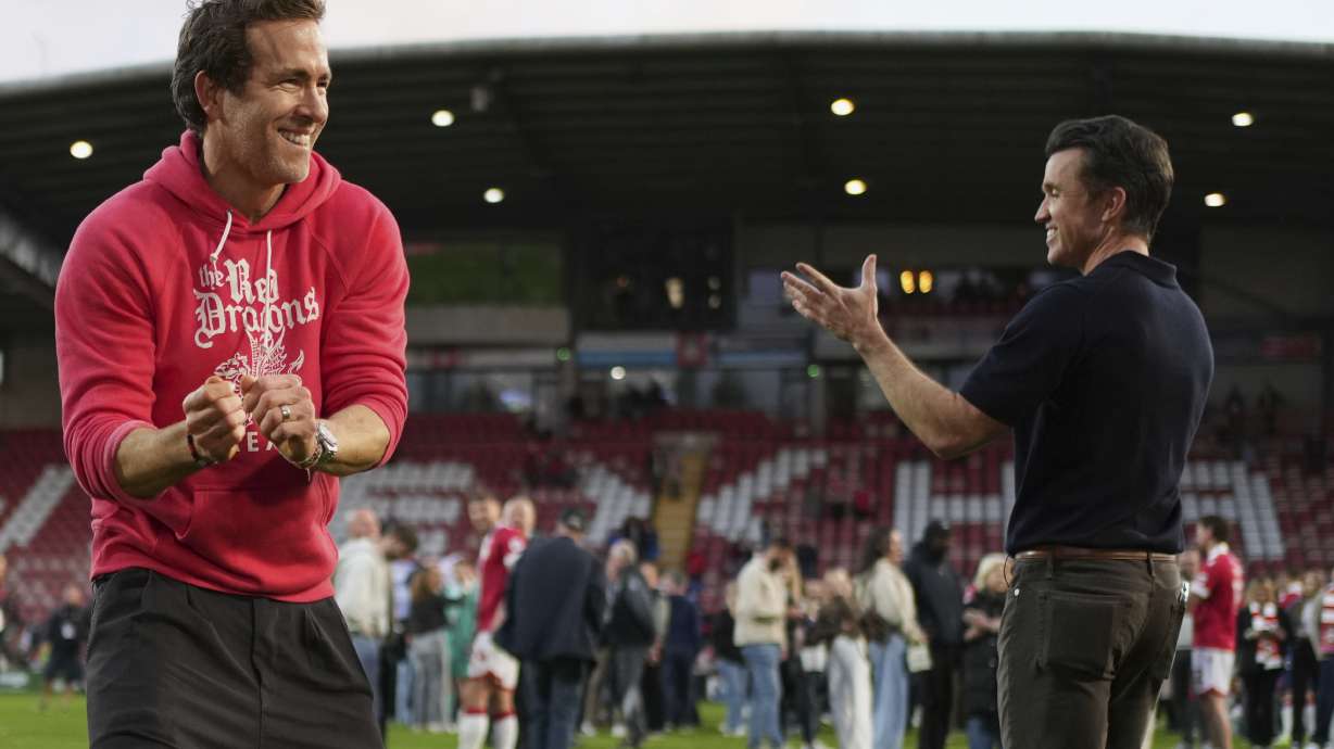 Wrexham co-owners Ryan Reynolds, left, and Rob McElhenney celebrate at the end of the English League One soccer match between Wrexham and Charlton Athletic at the Racecourse ground in Wrexham, Wales, Saturday, April 26, 2025.