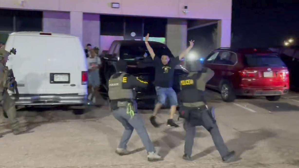 Officers stop a patron from a nightclub where a raid occurred Sunday in Colorado Springs, Colo.