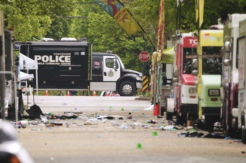 Evidence markers and Vancouver Police vehicles sit at a scene after a driver killed multiple people Saturday during a Filipino community festival Sunday in Vancouver, Canada.