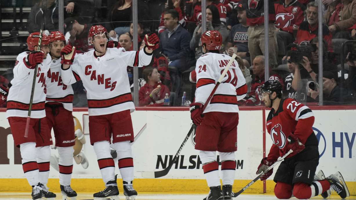 Carolina Hurricanes' Andrei Svechnikov, third from left, celebrates his goal with teammates as New Jersey Devils Brett Pesce, right, looks on during the second period of Game 4 of an NHL hockey first-round series, Sunday, April 27, 2025, in Newark, N.J.