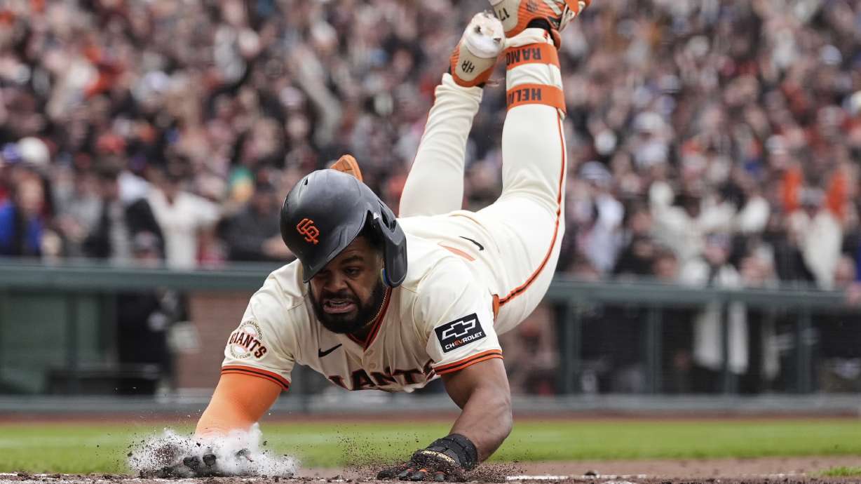 San Francisco Giants' Heliot Ramos scores the game-winning run on a throwing error Texas Rangers first baseman Jake Burger during the ninth inning of a baseball game Sunday, April 27, 2025, in San Francisco.