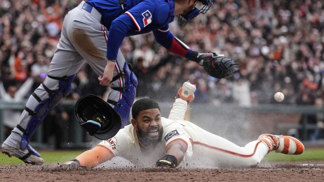 San Francisco Giants' Heliot Ramos scores the game-winning run on a throwing error Texas Rangers first baseman Jake Burger during the ninth inning of a baseball game Sunday, April 27, 2025, in San Francisco.