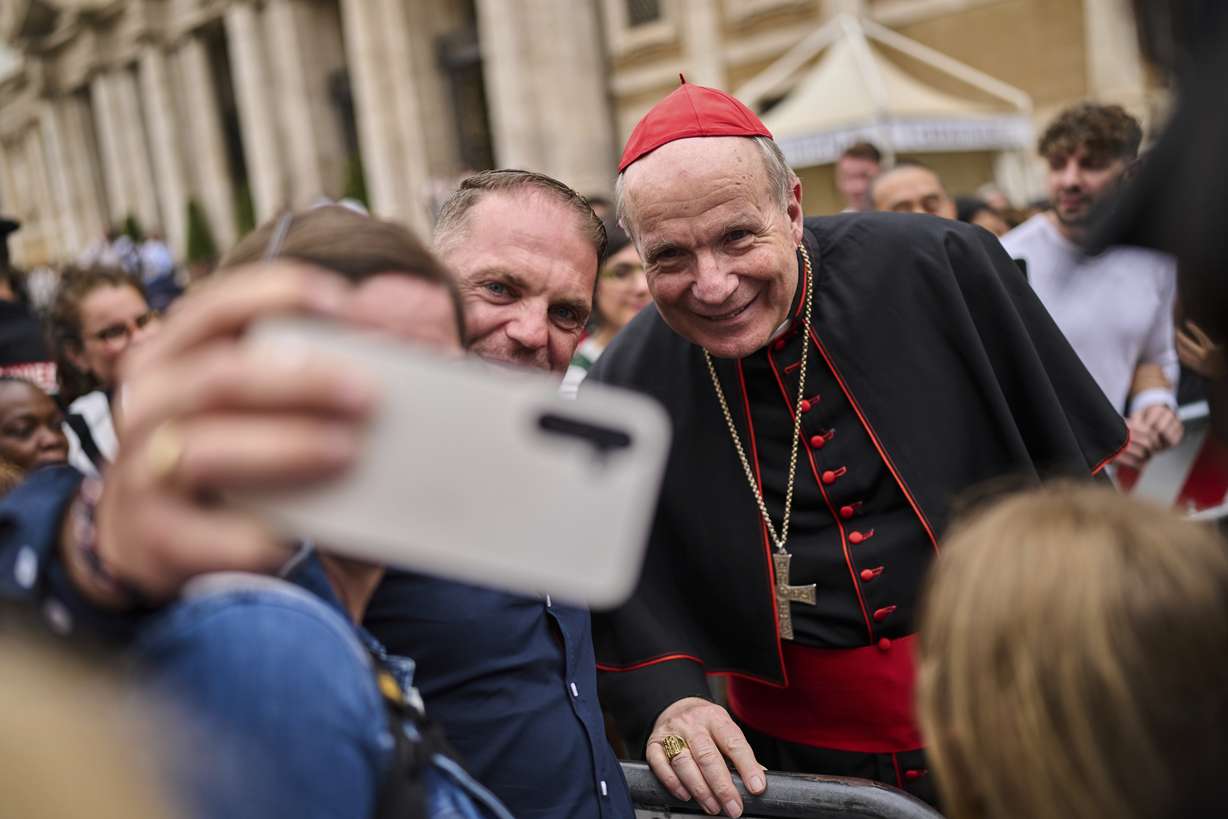 Cardinal Christoph Schönborn poses for selfie photos with people outside St. Mary Major Basilica in Rome, Sunday.