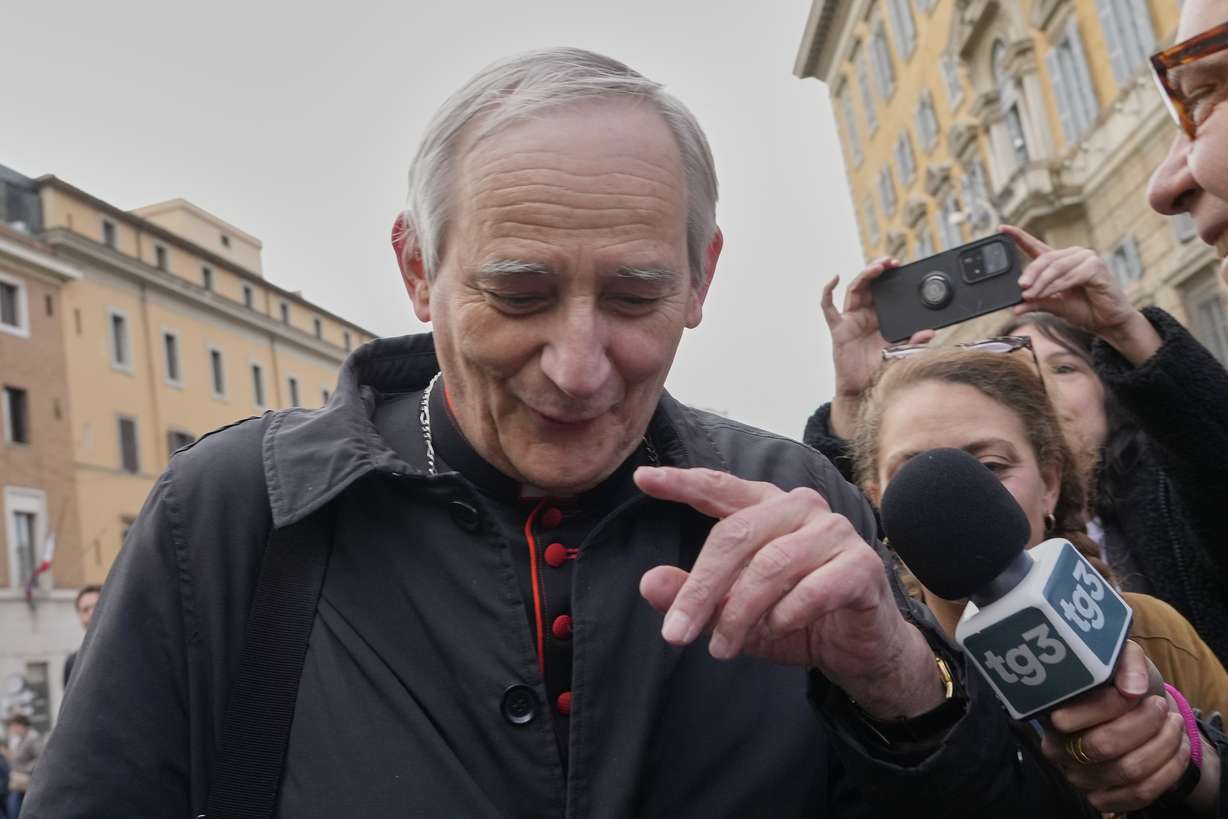 Cardinal Matteo Zuppi is approached by reporters as he arrives for a college of cardinals' meeting at the Vatican, Monday.