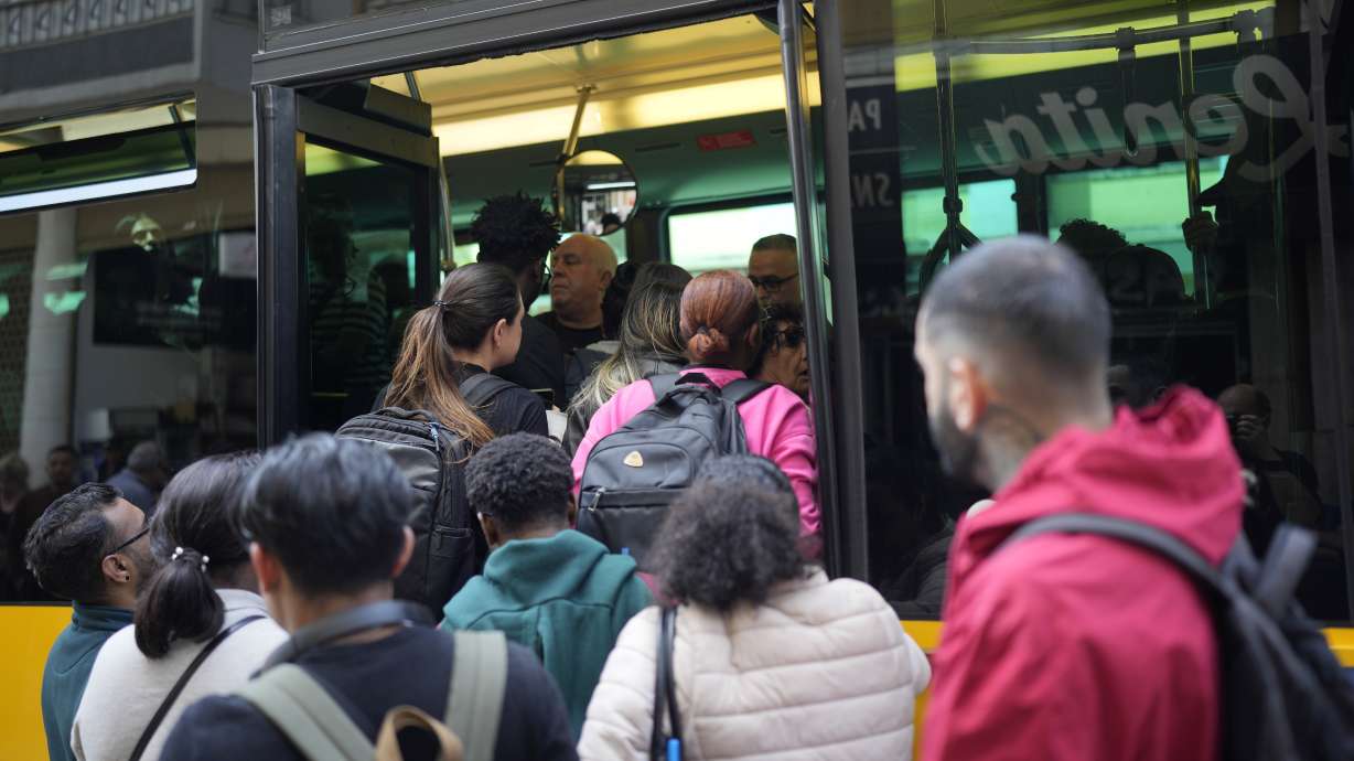People try to board a crowded bus after the subway stopped running following a power outage in Lisbon, Portugal, Monday.