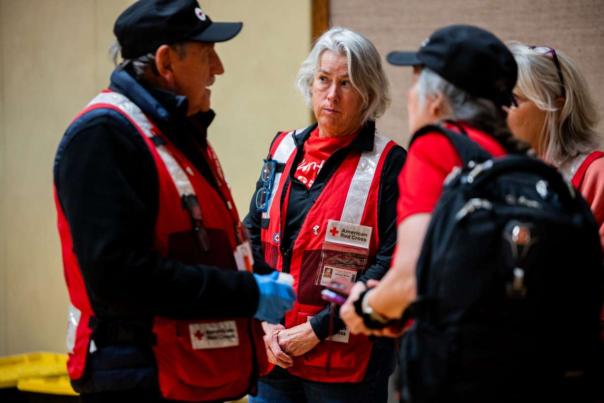 American Red Cross Disaster Team associate Margaret Moore, center, speaks with colleagues in an evacuation shelter at The Church of Jesus Christ of Latter-day Saints building in South Salt Lake on Sunday.