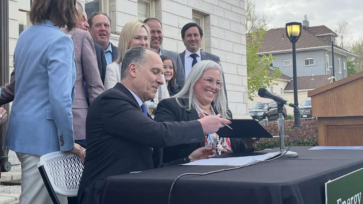 John Wagner and Emy Lesofski exchange copies of a memorandum of understanding outside the Governor's Mansion in Salt Lake City on Monday. The state plans to explore nuclear energy opportunities further.