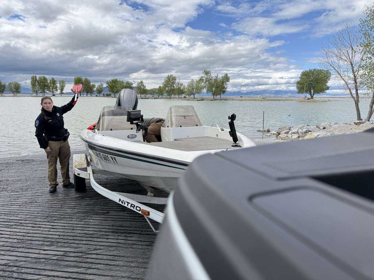 Department of Natural Resources Sgt. Sierra Schaefer holds up a paddle while talking boating safety at Utah Lake on Monday.