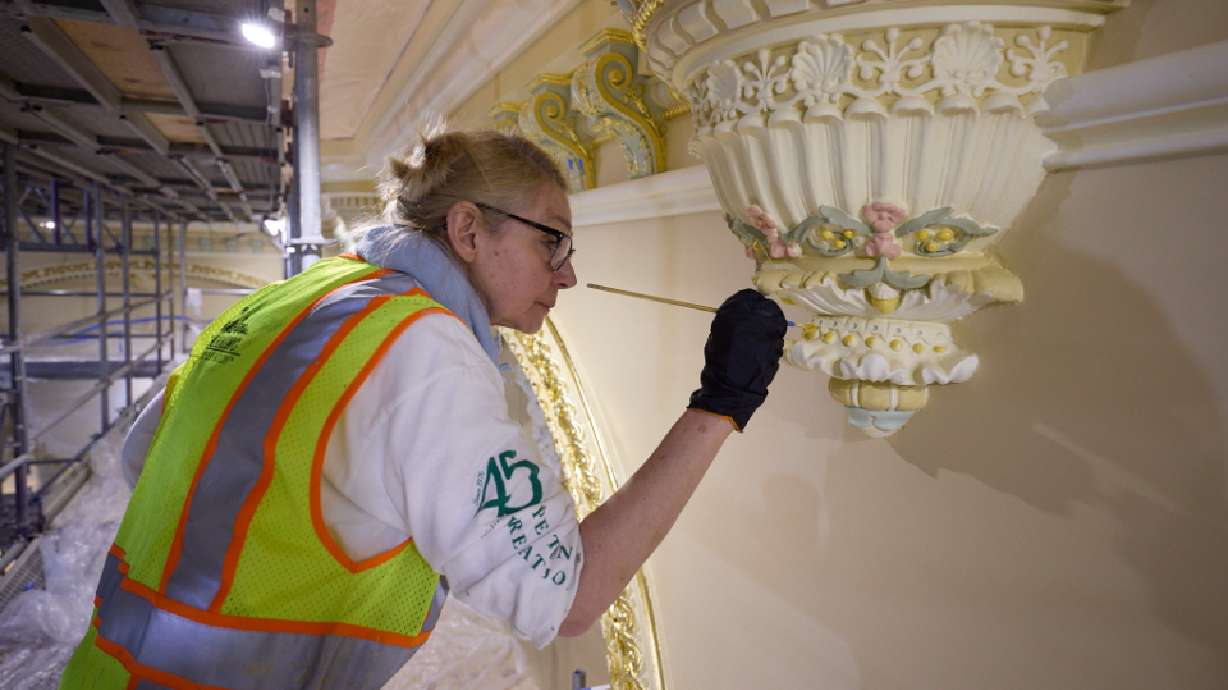 A woman paints intricate finish work on the ceiling of the celestial room in the Salt Lake Temple on April 22.