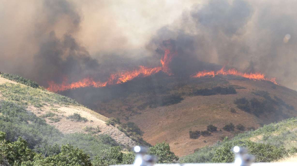A wildfire burns in the area around Ensign peak in Salt Lake City on July 20, 2024. The Climate Prediction Center recently released its summer forecast, indicating that temperatures will likely soar above seasonal averages throughout the U.S.