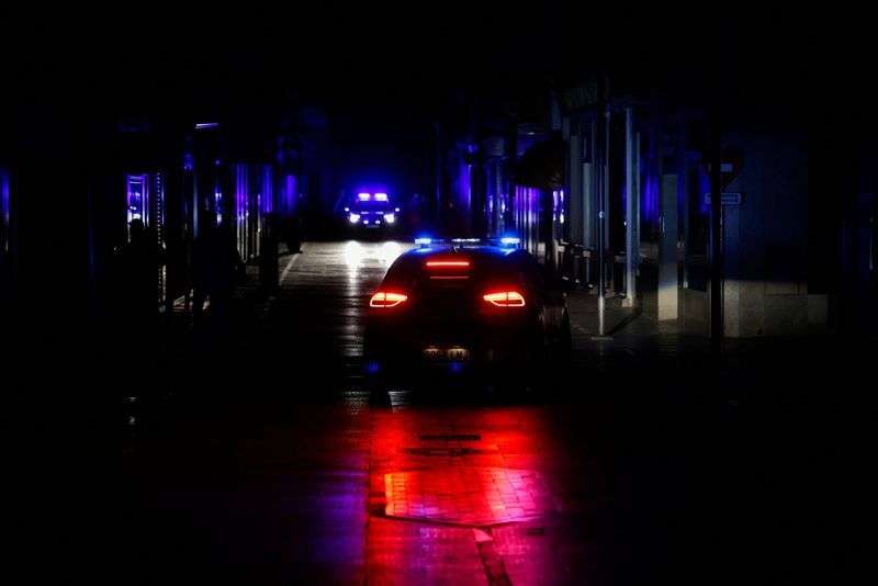 Police car patrols a shopping street without electric lighting to prevent theft and looting in the stores during a power outage which hit large parts of Spain, in Ronda, Spain, Monday.