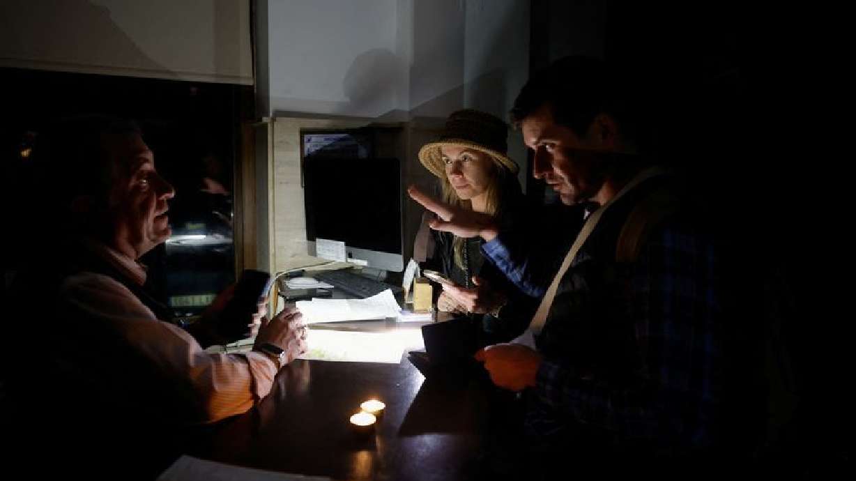 Tourists check into a hotel without electricity during a power outage that hit large parts of Spain on Monday.