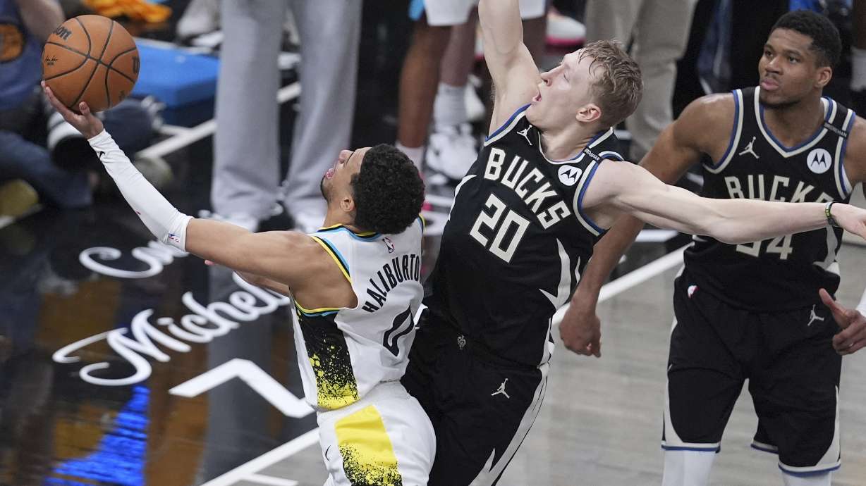 Milwaukee Bucks guard AJ Green (20) fouls Indiana Pacers guard Tyrese Haliburton (0) as he shoots during overtime in Game 5 of an NBA basketball first-round playoff series in Indianapolis, Tuesday, April 29, 2025.