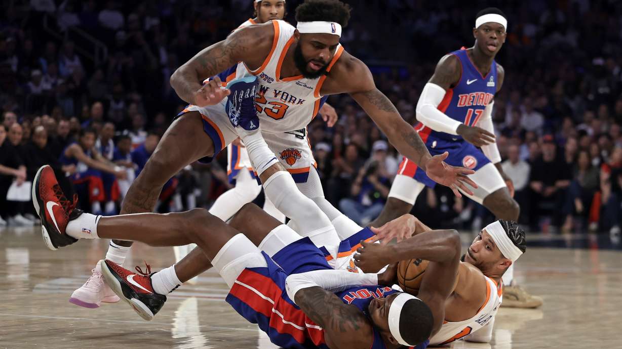 New York Knicks center Mitchell Robinson (23) and Josh Hart fight for a loose ball with Detroit Pistons forward Paul Reed during Game 5 in an NBA basketball first-round playoff series Tuesday, April 29, 2025, in New York.