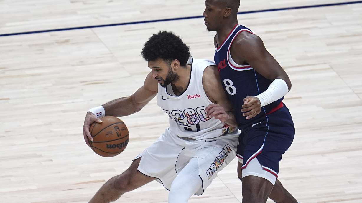 Denver Nuggets guard Jamal Murray, left, works the ball to the basket as Los Angeles Clippers guard Kris Dunn defends in the first half of Game 5 of an NBA basketball playoff series Tuesday, April 29, 2025, in Denver.