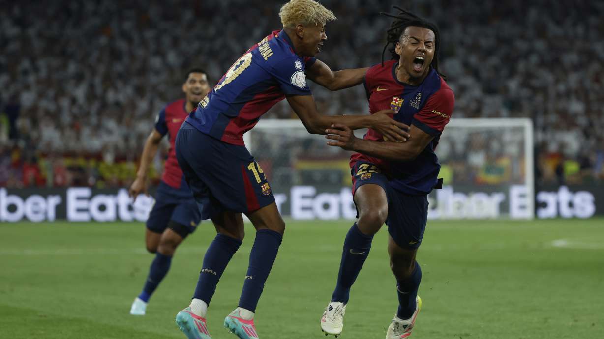 Barcelona's Jules Kounde, right, celebrates after scoring his side's third goal during the Spanish Copa del Rey final soccer match between Barcelona and Real Madrid at Estadio de La Cartuja stadium in Seville, Spain, Sunday, April 27, 2025.
