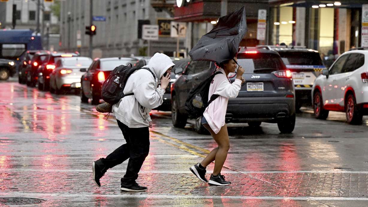 Pedestrians rush across Smithfield St. in the rain in downtown Pittsburgh on Tuesday.