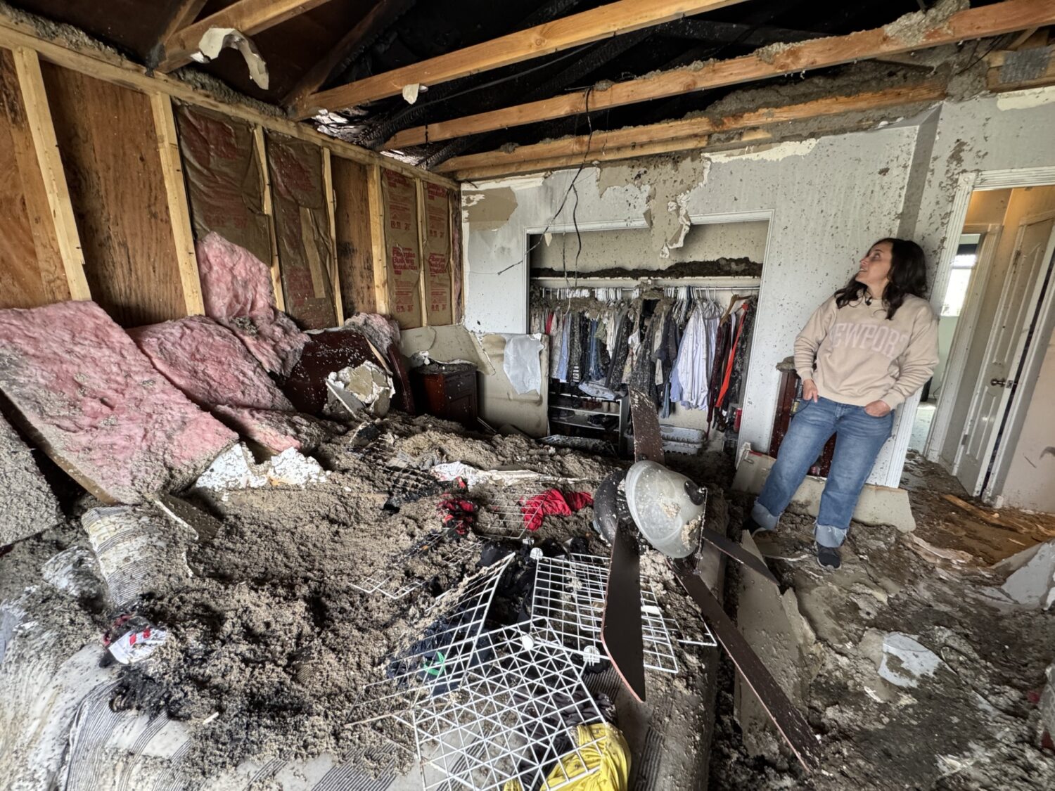 Holly Hendrickson looks at the damage to her master bedroom after a fire on Saturday.