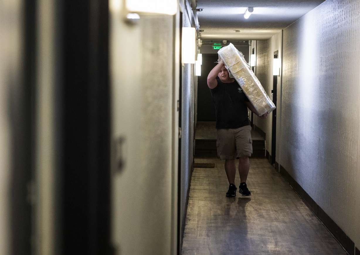 Ron Tait, a mover with the Other Side Thrift Boutique, carries a box spring while moving furniture donated by the North Star Hope Foundation’s Furnishing Futures program into Stephanie Pickering’s apartment in Salt Lake City on Wednesday.