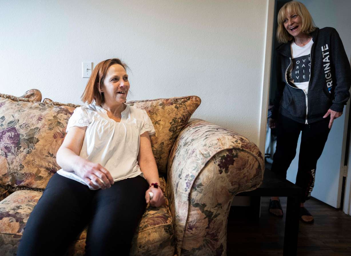 Stephanie Pickering, left, sits down on her new couch donated by the North Star Hope Foundation’s Furnishing Futures program and laughs with her roommate Heather James, right, about how comfy it is compared to their last couch, in their apartment in Salt Lake City on Wednesday.