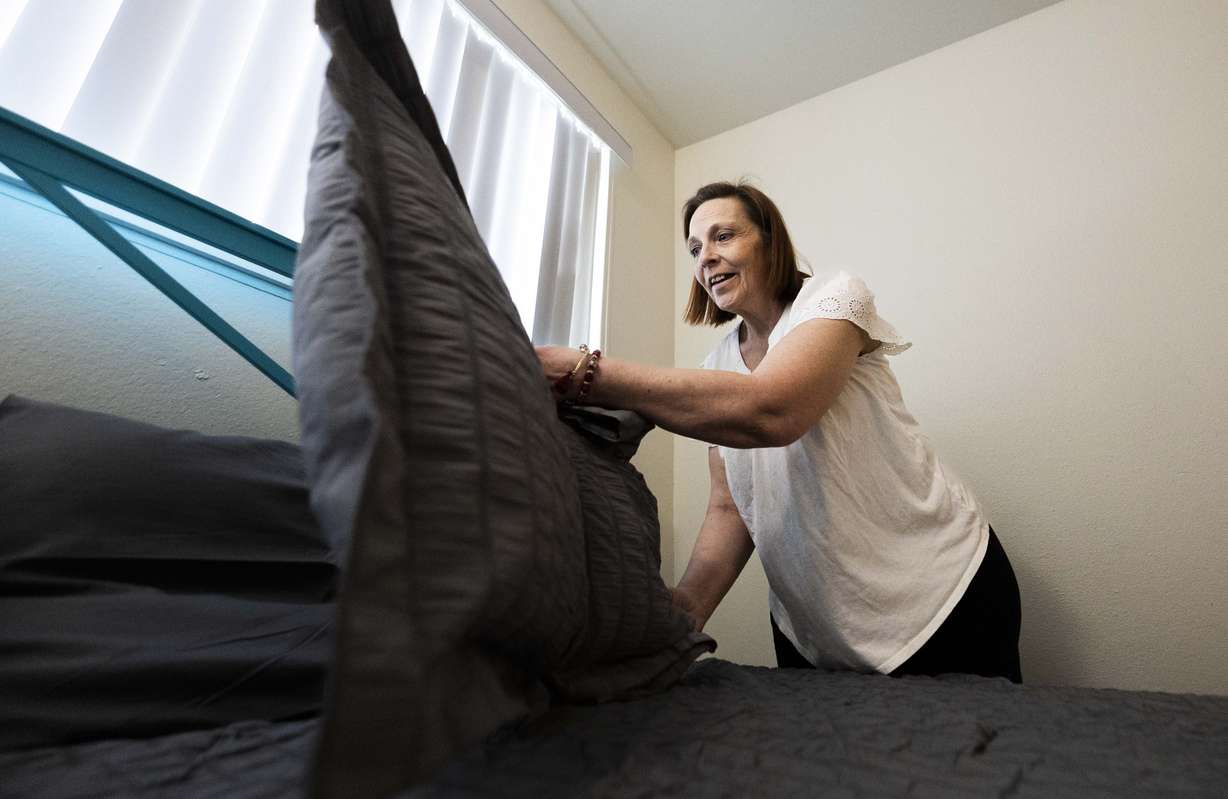 Stephanie Pickering makes the bed after receiving a new bed and other furniture donated by the North Star Hope Foundation’s Furnishing Futures program, at Pickering’s apartment in Salt Lake City on Wednesday.