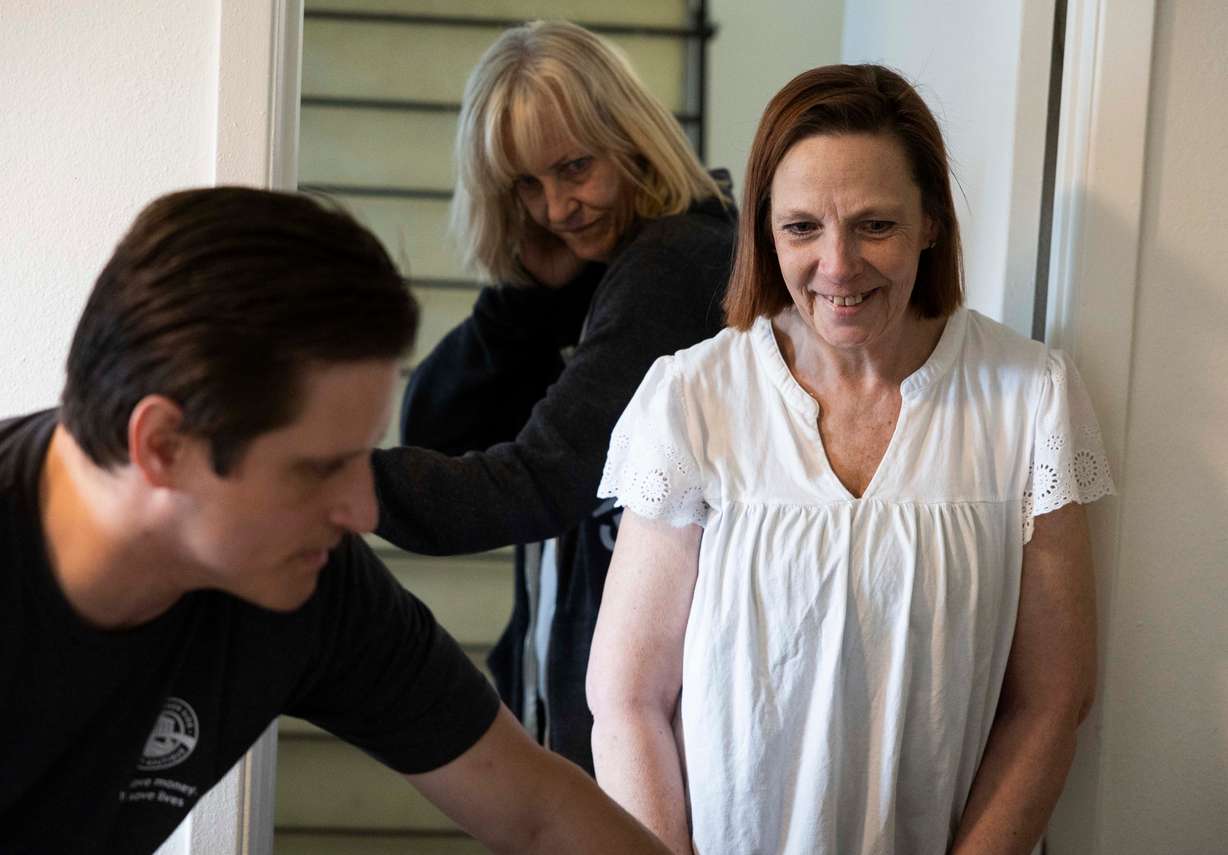 Stephanie Pickering, right, smiles as Shawn Slaymaker, a mover with the Other Side Thrift Boutique, left, moves furniture donated by the North Star Hope Foundation’s Furnishing Futures program into Pickering’s apartment in Salt Lake City on Wednesday.