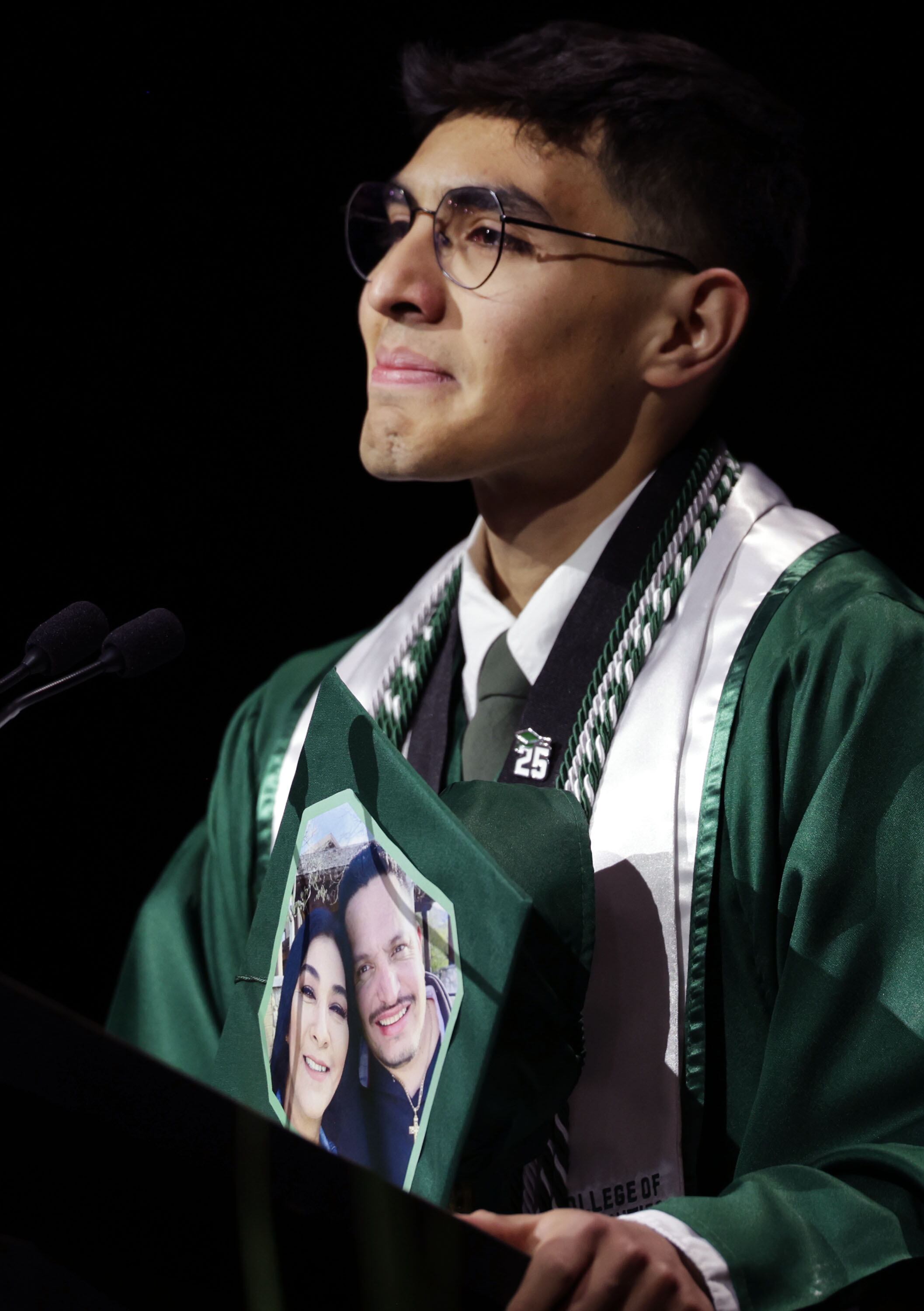 Utah Valley University student speaker Francisco Calderon-Mora displays his mortarboard that he decorated with a photograph of his parents at the 2025 commencement ceremony in the UCCU Center at Utah Valley University in Orem on Wednesday.