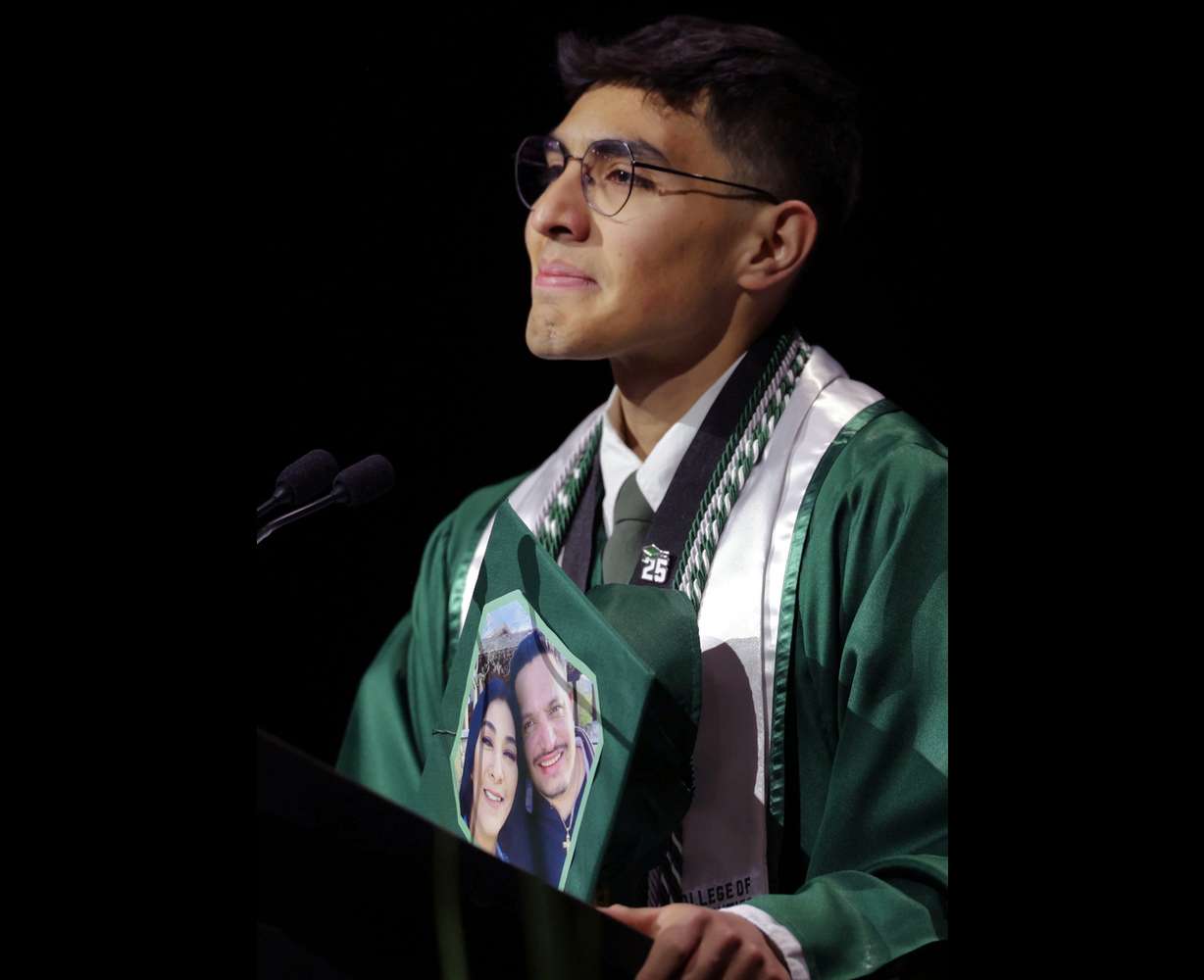 Utah Valley University student speaker Francisco Calderon-Mora displays his mortarboard that he decorated with a photograph of his parents at the 2025 commencement ceremony in the UCCU Center at Utah Valley University in Orem on Wednesday.
