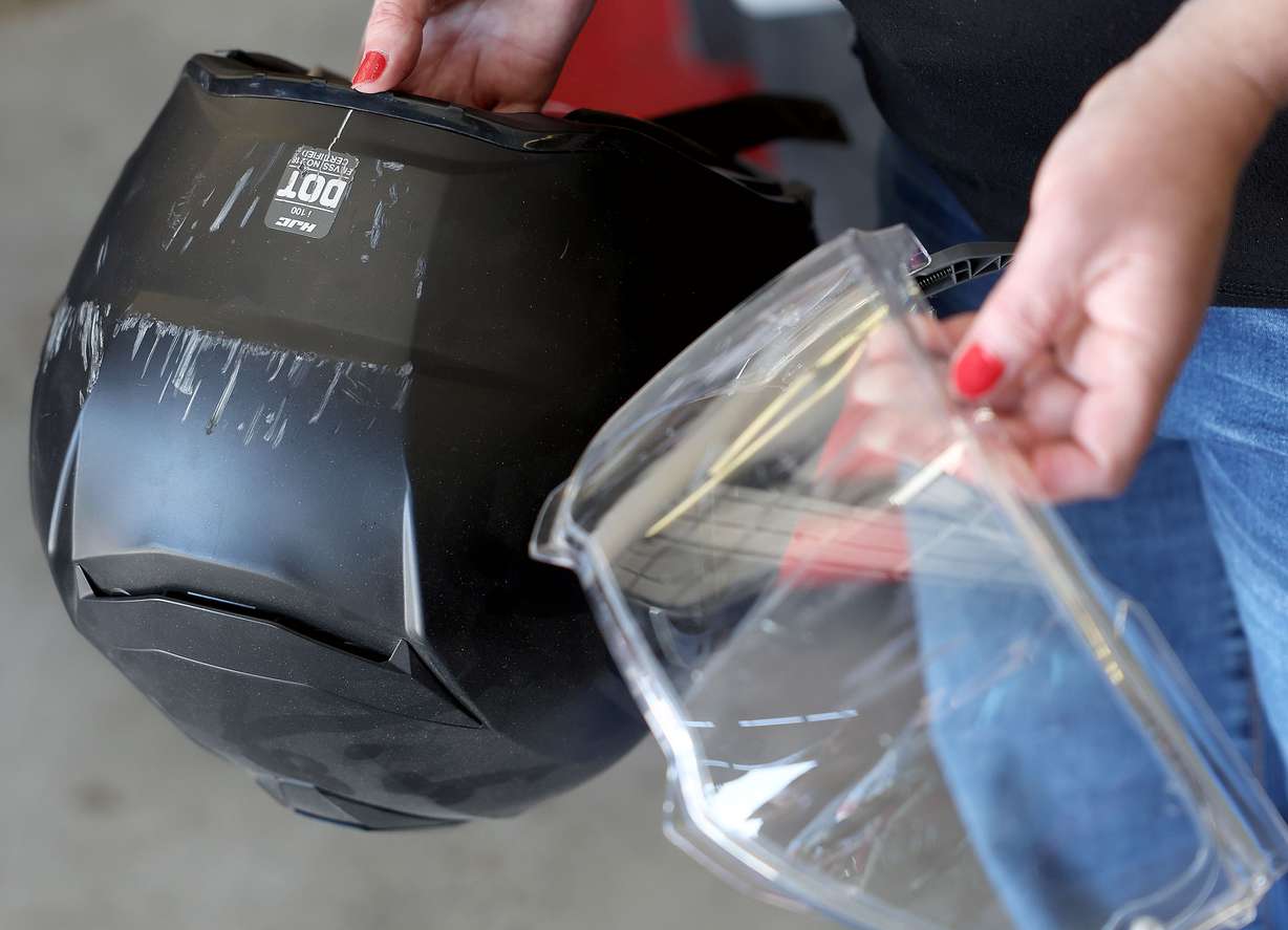 Rachel Trim shows the scratches on her helmet and visor from an accident that occurred a year ago in West Jordan on Thursday. Trim was wearing the helmet and other protective gear when she was hit.
