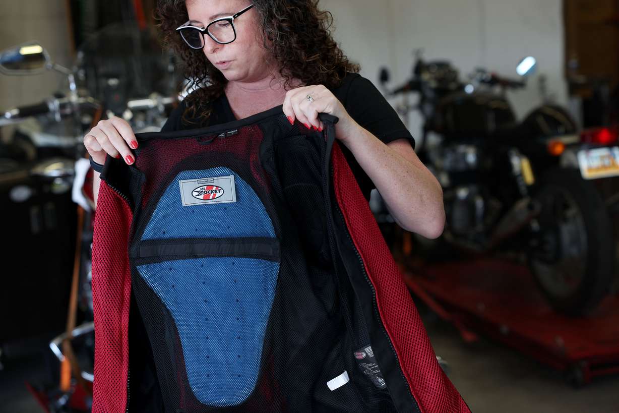 Rachel Trim shows the back plate of her crash jacket during a press conference about the importance of motorcyclists taking a rider safety course and obtaining a state-mandated motorcycle endorsement at Turn & Learn in West Jordan on Thursday. Trim credits her crash jacket for preventing more serious injuries from a motorcycle crash that she was involved in a year ago.