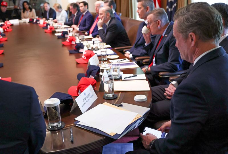 National security adviser Mike Waltz checks his mobile phone while attending a cabinet meeting held by President Donald Trump at the White House in Washington, D.C., Wednesday.