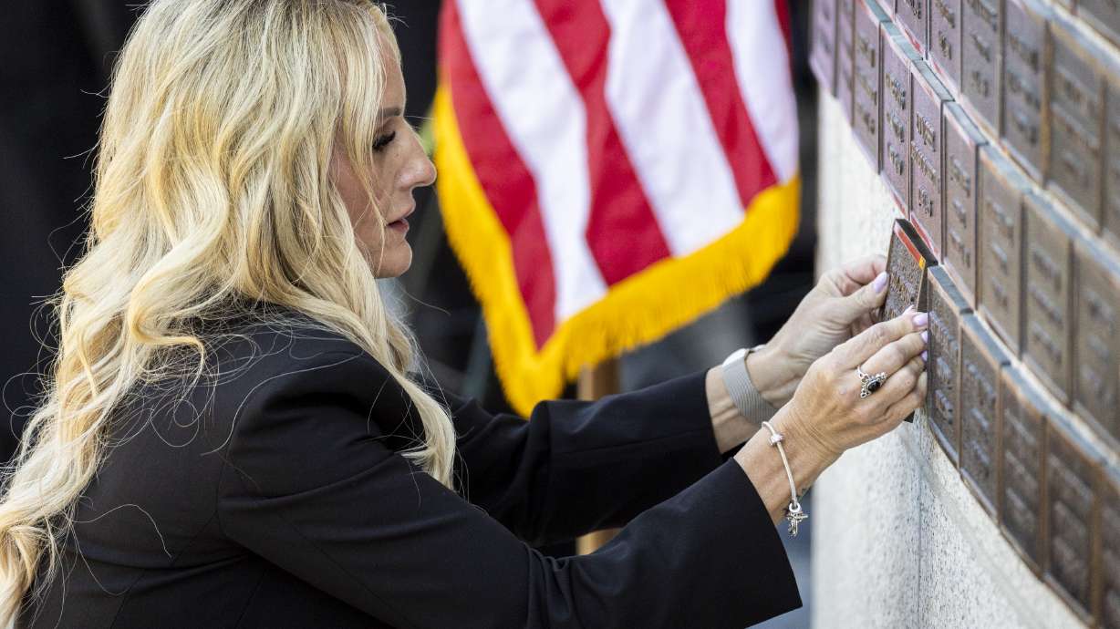 Kinda Hooser, wife of the late Santaquin Police Sgt. Billy D. Hooser, places a plaque for her late husband at the Utah Law Enforcement Memorial outside the Capitol in Salt Lake City on Thursday.