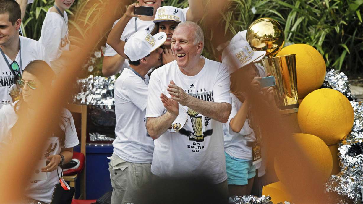 San Antonio Spurs head coach Gregg Popovich, center, claps during the basketball team's parade and celebration for their fifth NBA Championship, Wednesday, June 18, 2014, in San Antonio.